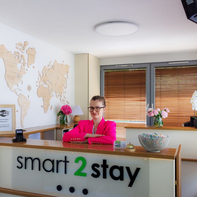 Recepcja Smart2Stay z logo nad ladą