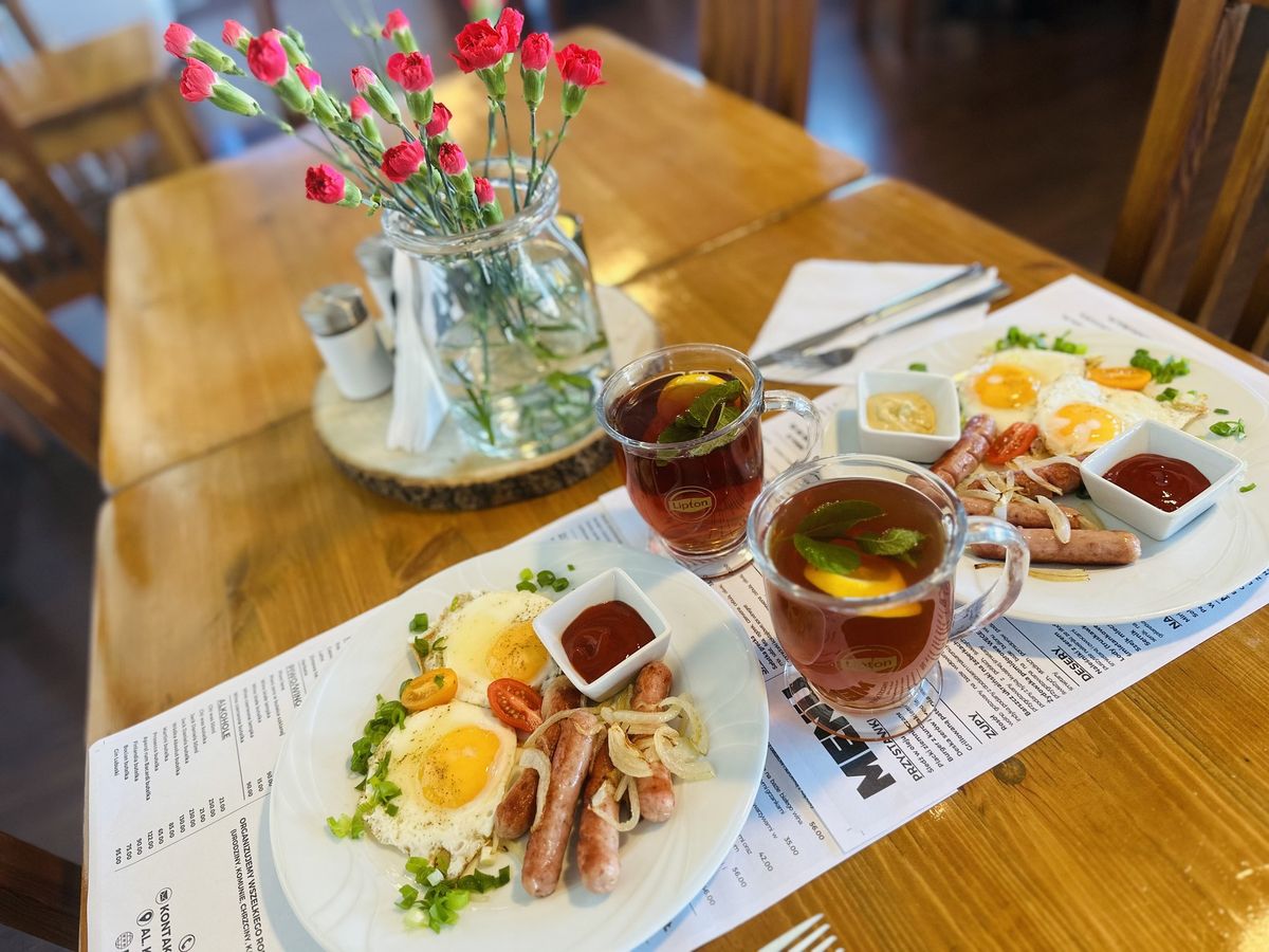 Śniadanie w restauracji U Jakuba: jajka sadzone, kiełbaski i herbata z cytryną